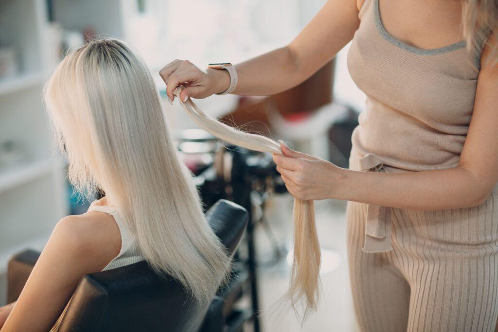 Frau beim Friseur bekommt Extensions