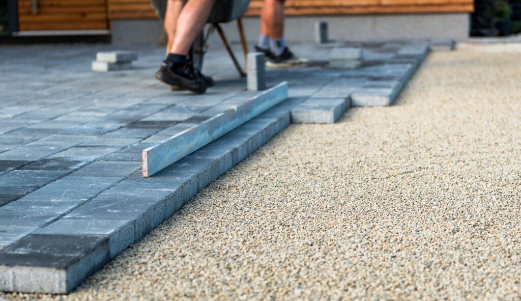 Pflasterarbeiten mit grauen Steinen im Garten | professionelle Terrassenüberdachung München